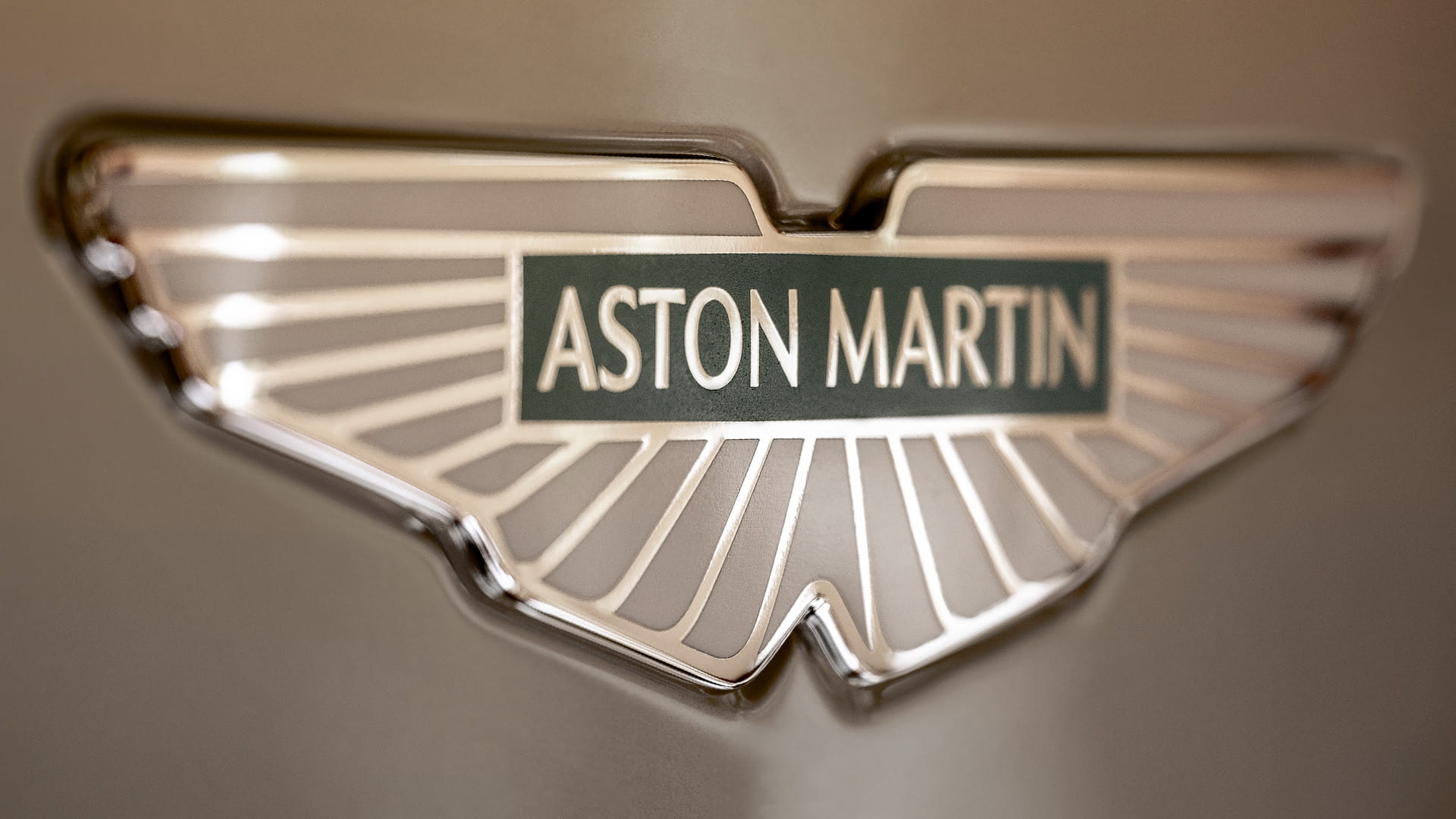 Aston Martin wings badge shown in close up on the hood of Db12 Goldfinger Edition