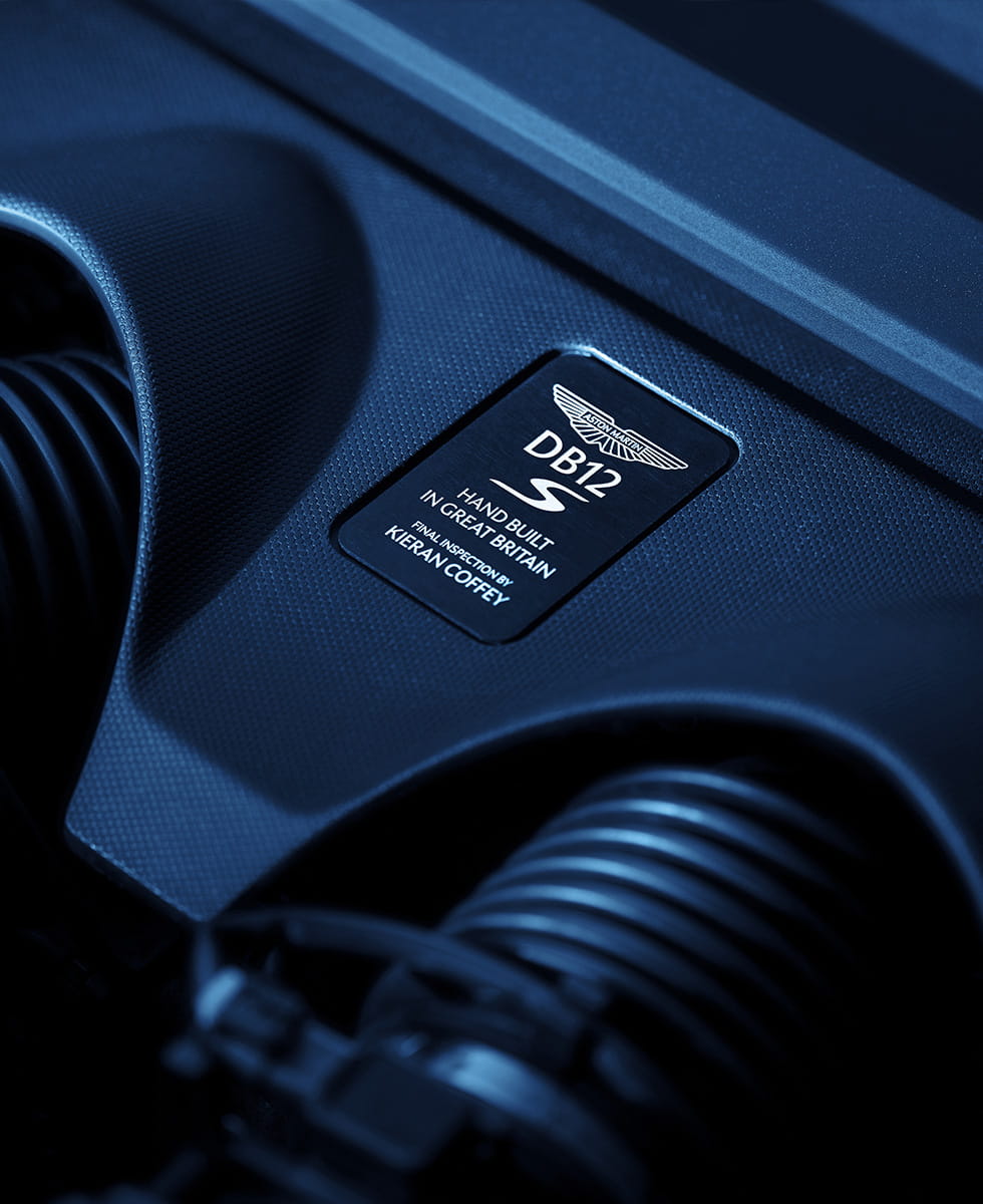 A close up of a badge on DB12 S' engine panel