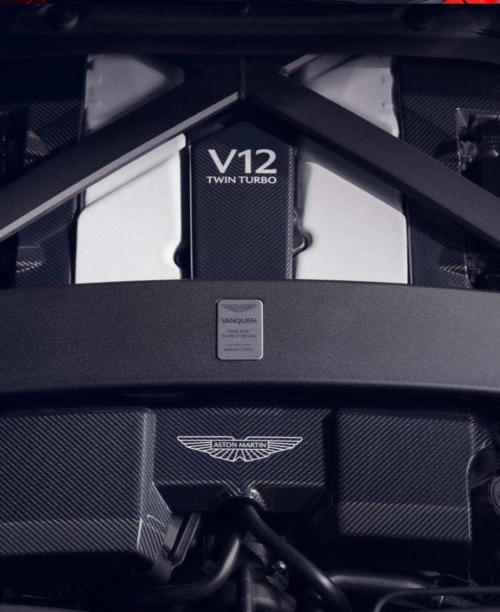 Image shows a close up of the black Aston Martin V12 engine cover